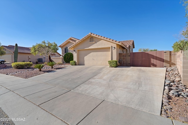 view of front facade featuring driveway, a garage, fence, and stucco siding