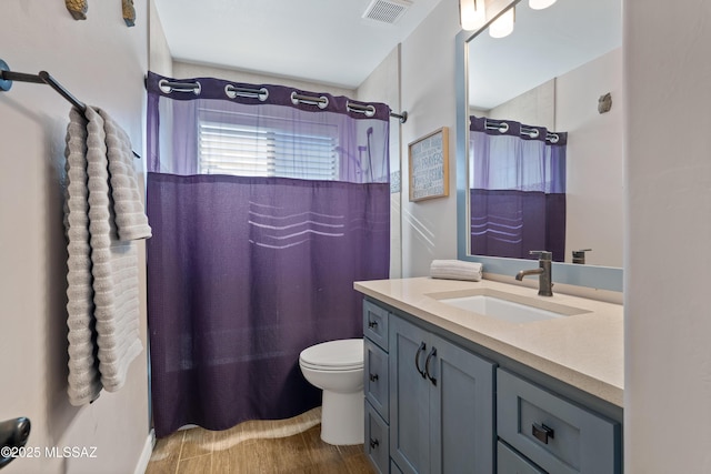 full bathroom featuring toilet, curtained shower, vanity, and visible vents