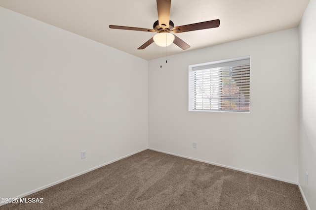 carpeted spare room with ceiling fan and baseboards