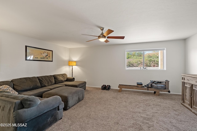 carpeted living area with a ceiling fan and baseboards