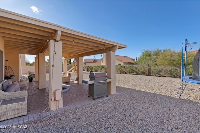 view of patio with a grill, a trampoline, and a fenced backyard