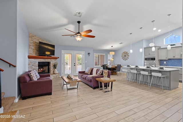 living area with a ceiling fan, a healthy amount of sunlight, visible vents, and light wood-style flooring