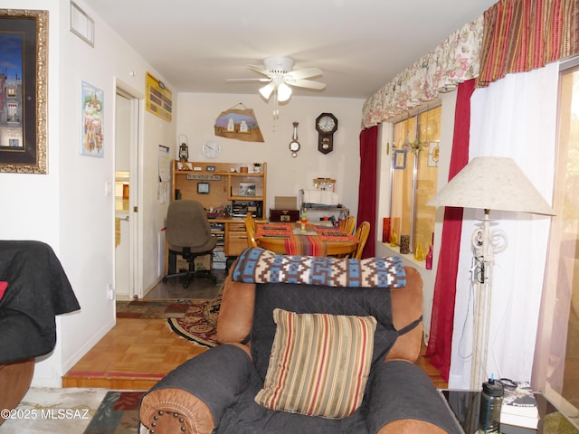 living area featuring visible vents and a ceiling fan