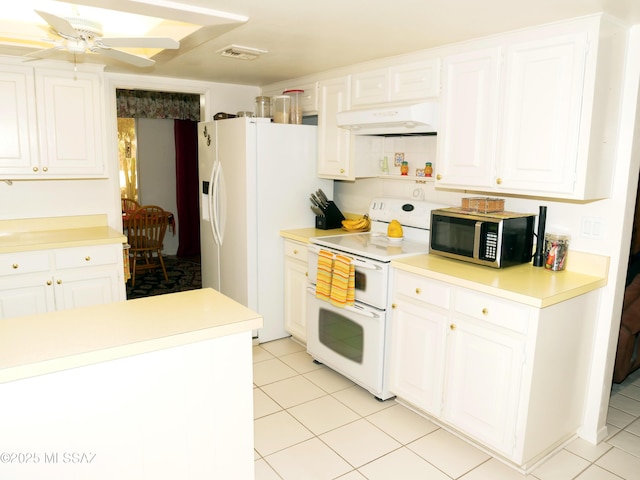 kitchen featuring white cabinets, visible vents, white appliances, under cabinet range hood, and light tile patterned floors