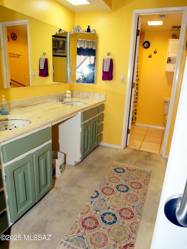 bathroom with baseboards, toilet, and vanity