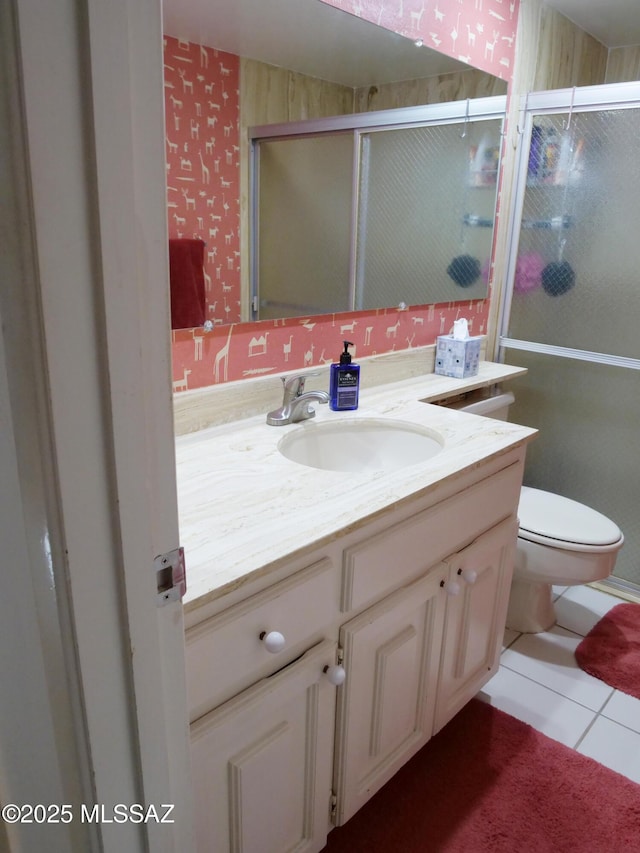 bathroom featuring vanity, toilet, tile patterned flooring, and a stall shower