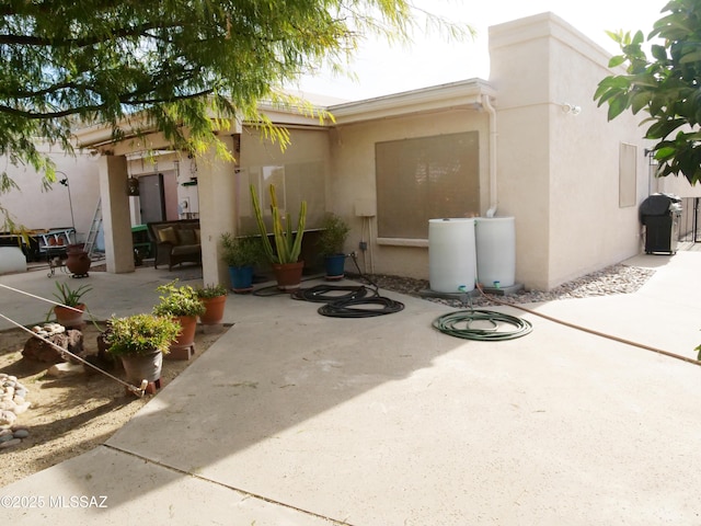 exterior space with stucco siding and a patio area