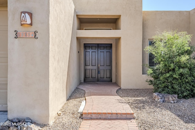 view of exterior entry with stucco siding