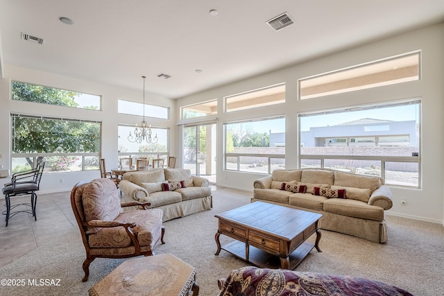 living room featuring plenty of natural light, visible vents, and an inviting chandelier