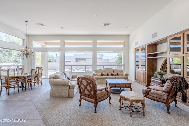 living room with a chandelier, visible vents, a towering ceiling, and light tile patterned floors