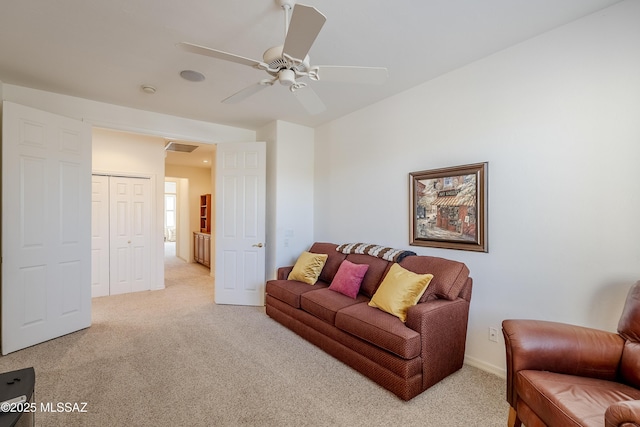 living area with light carpet, visible vents, and a ceiling fan