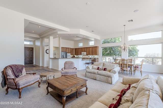 living area with recessed lighting, visible vents, a high ceiling, a chandelier, and baseboards