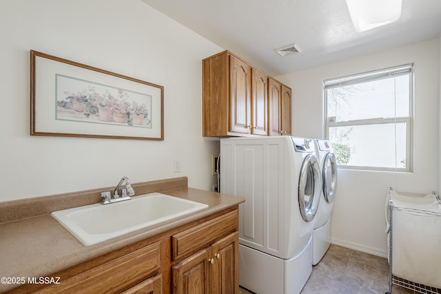 clothes washing area featuring light tile patterned floors, cabinet space, visible vents, washing machine and dryer, and a sink