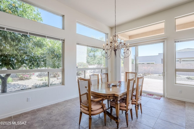 dining area with tile patterned floors, baseboards, and an inviting chandelier