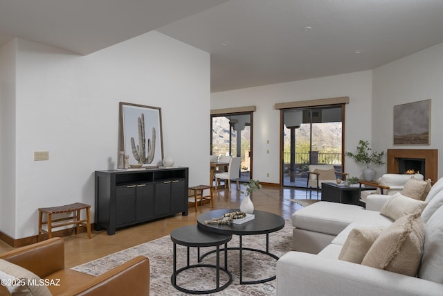 living area with light tile patterned flooring, baseboards, and a lit fireplace