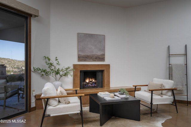 living room with baseboards and a lit fireplace