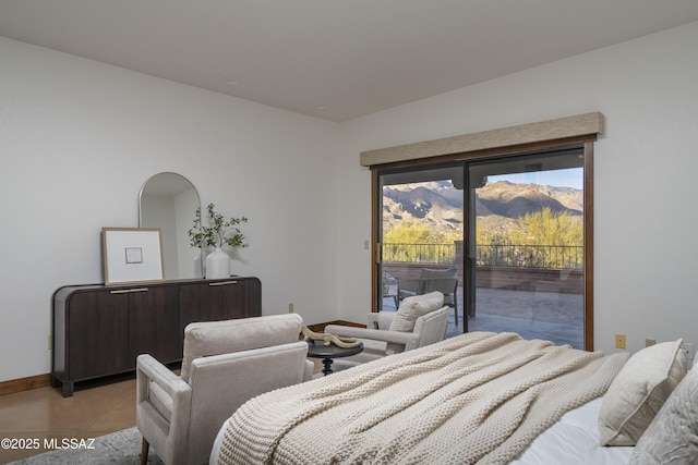 bedroom with access to exterior, a mountain view, light tile patterned flooring, and baseboards