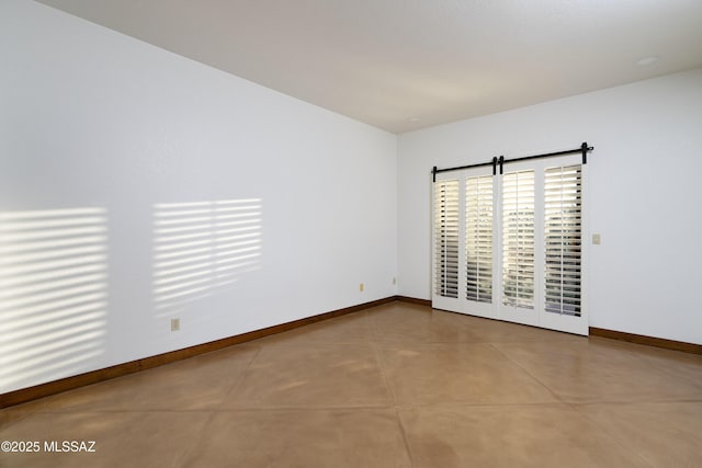 unfurnished room featuring finished concrete flooring and baseboards