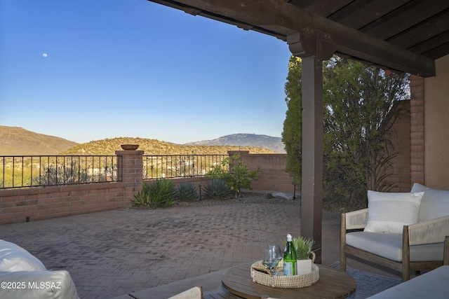 view of patio with a mountain view and fence