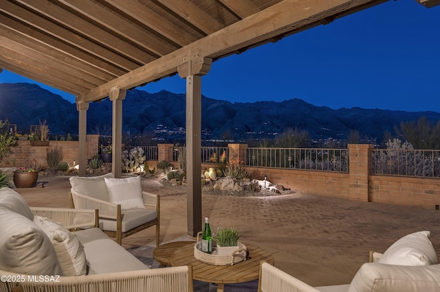 view of patio / terrace featuring a mountain view, outdoor lounge area, and fence