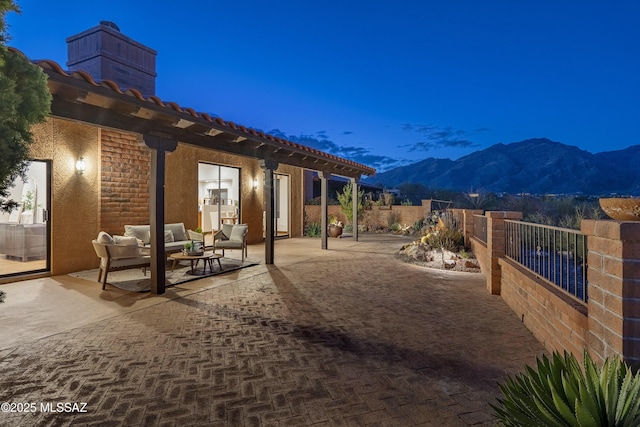 view of patio / terrace featuring an outdoor living space, a mountain view, and fence