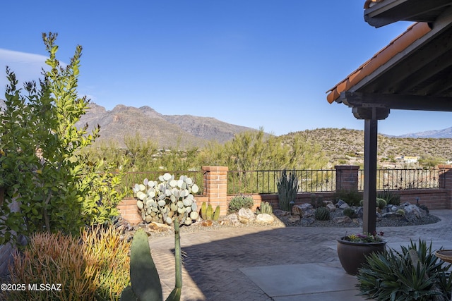 view of patio featuring a mountain view and fence