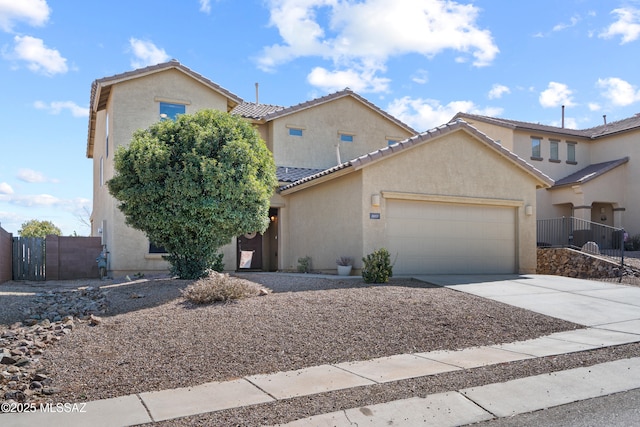 view of front of home featuring driveway, a garage, fence, and stucco siding