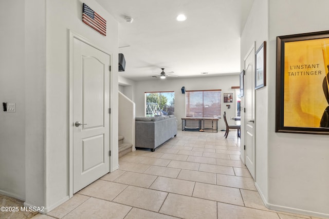 hall featuring recessed lighting, light tile patterned flooring, baseboards, and stairs