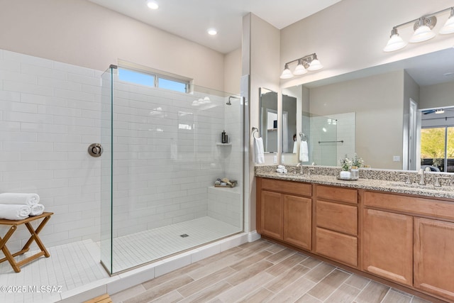 bathroom with vanity and a tile shower