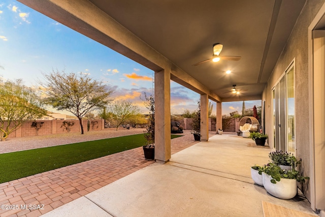 patio terrace at dusk featuring ceiling fan