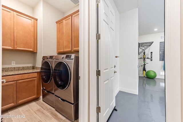 washroom with cabinets and washing machine and clothes dryer