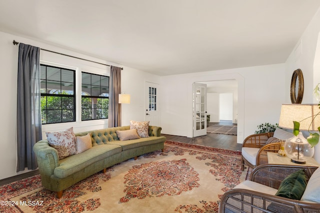 living area featuring arched walkways and wood finished floors