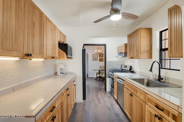 kitchen featuring tasteful backsplash, dark wood-style floors, stainless steel appliances, light countertops, and a sink