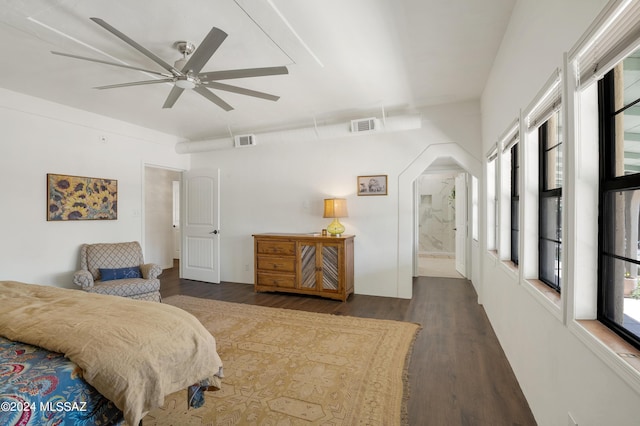 bedroom with arched walkways, ceiling fan, wood finished floors, and visible vents