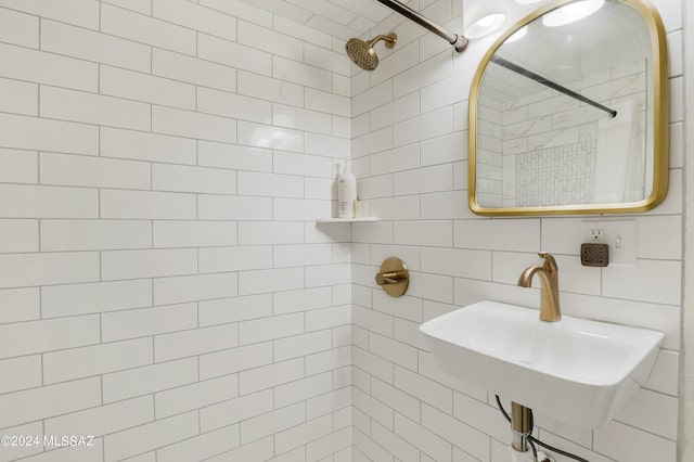 full bathroom with backsplash, a tile shower, and a sink