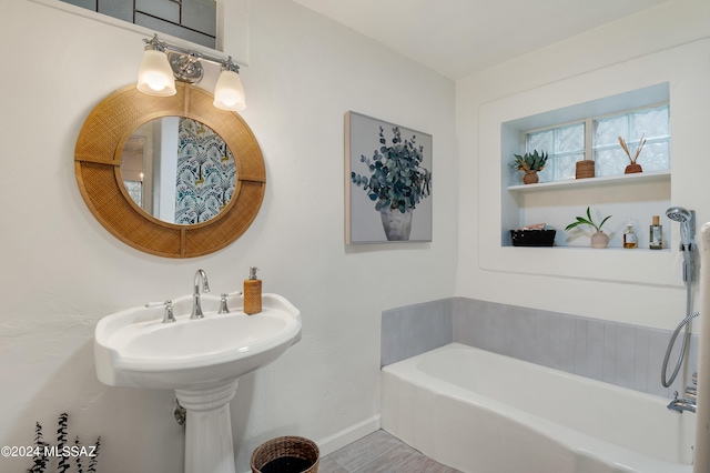 bathroom featuring a washtub and baseboards