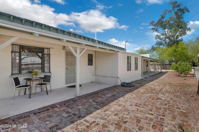 back of house with a patio area, fence, and stucco siding