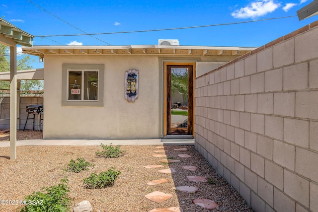 view of exterior entry with stucco siding