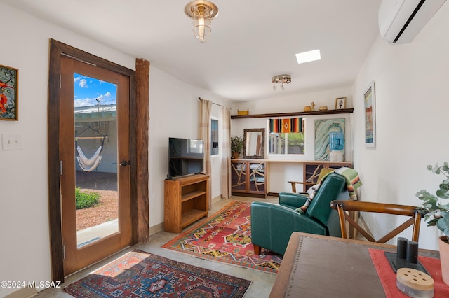 living room with a wall mounted air conditioner, concrete floors, and baseboards