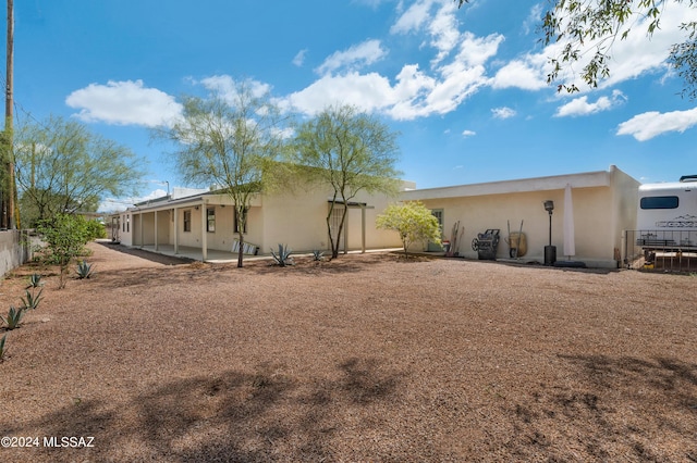 back of house featuring a patio area, fence, and stucco siding