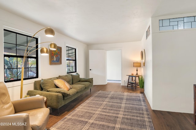 living room with a baseboard heating unit, wood finished floors, and visible vents