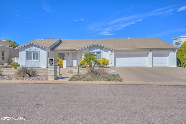 ranch-style house with a tiled roof, stucco siding, an attached garage, and concrete driveway