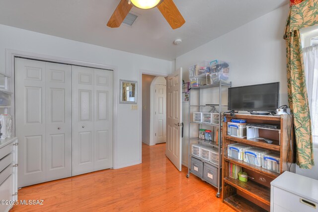 living area with light wood-style floors, a ceiling fan, and visible vents