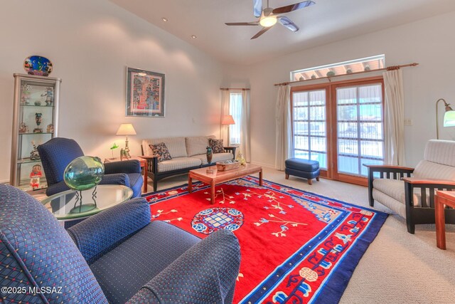 carpeted living area featuring a ceiling fan and high vaulted ceiling