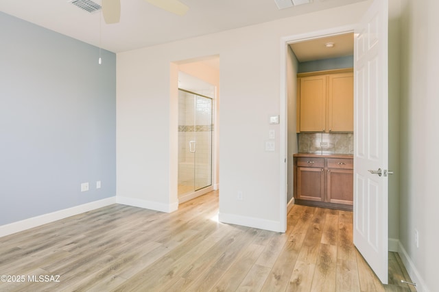 unfurnished bedroom with ensuite bathroom and light hardwood / wood-style flooring