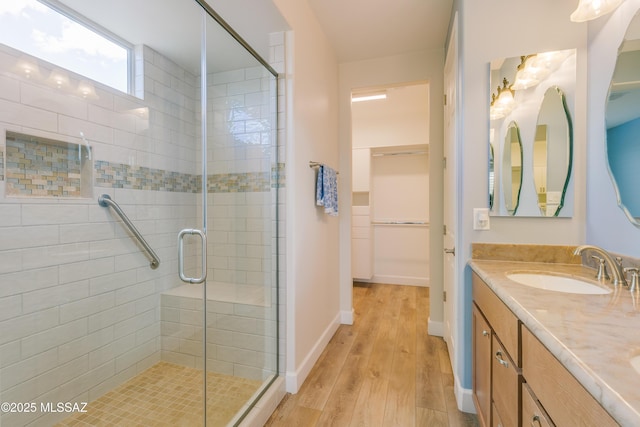 bathroom with wood-type flooring, vanity, and a shower with shower door