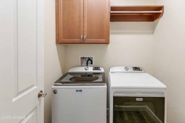 washroom with cabinets and washer and clothes dryer