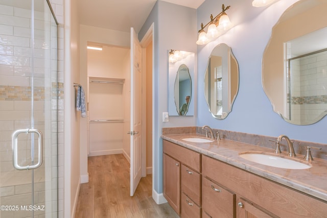 bathroom with an enclosed shower, hardwood / wood-style floors, and vanity