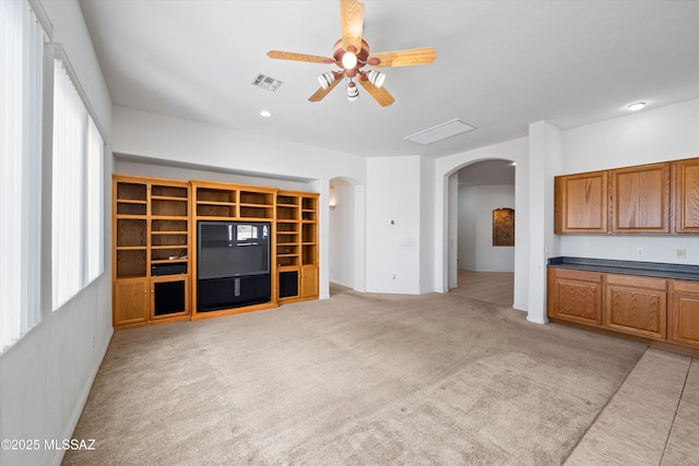 unfurnished living room featuring light colored carpet and ceiling fan