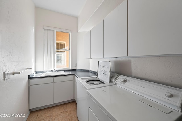 laundry area featuring cabinets, light tile patterned flooring, washer and dryer, and sink